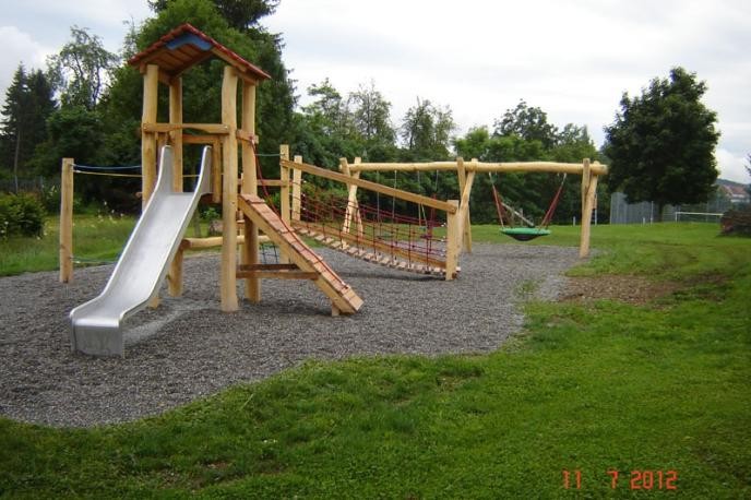 Kleinkinder-Spielplatz mit Vogelnestschaukel und Brückenaufstieg zur Rutschbahn