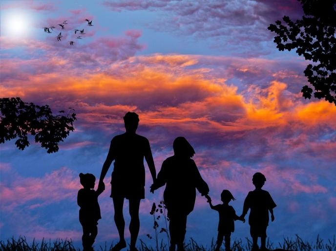 Eltern und Kinder beim Spaziergang in der Abenddämmerung