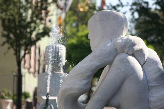 Vorstadtbrunnen mit Skulptur und Wasserfontäne
