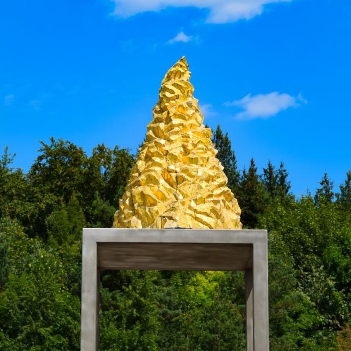 Vergoldete Bergspitze auf einem überdimensionierten Sockeltisch
